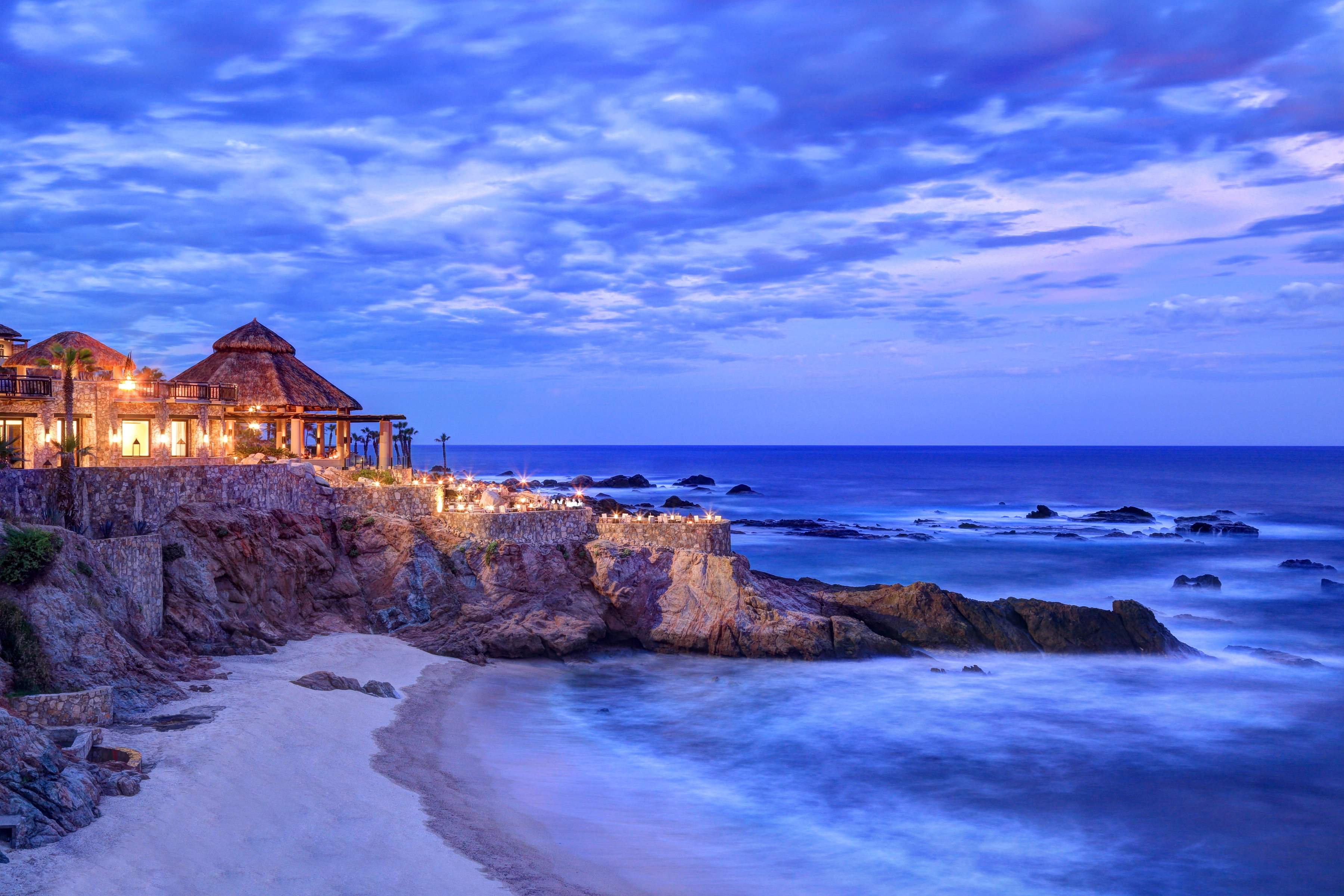 Cocina del Mar at Esperanza lit up at dusk on the cliff above the cove