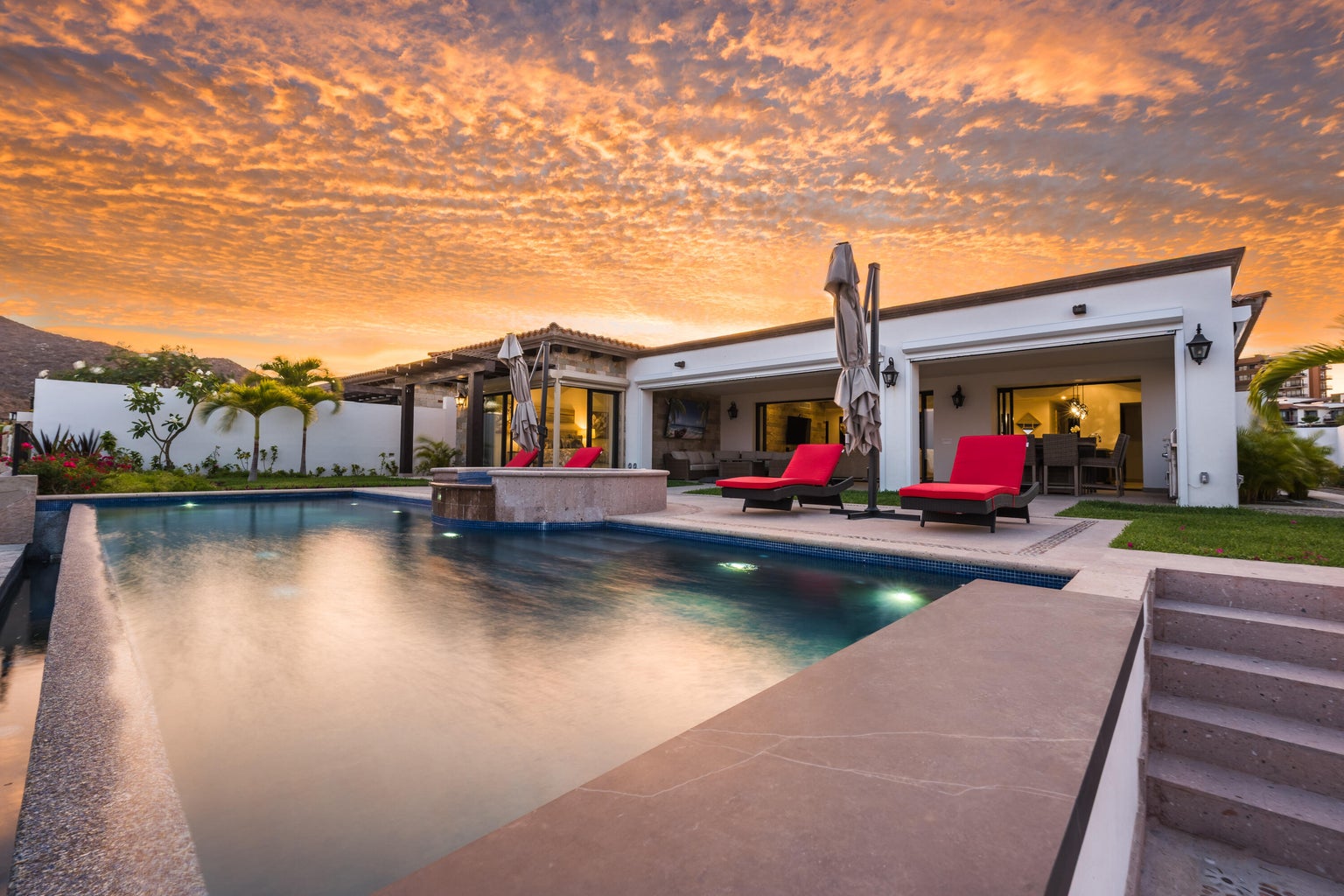 Coronado residence at Quivira, single level, pool and red loungers under an orange sky