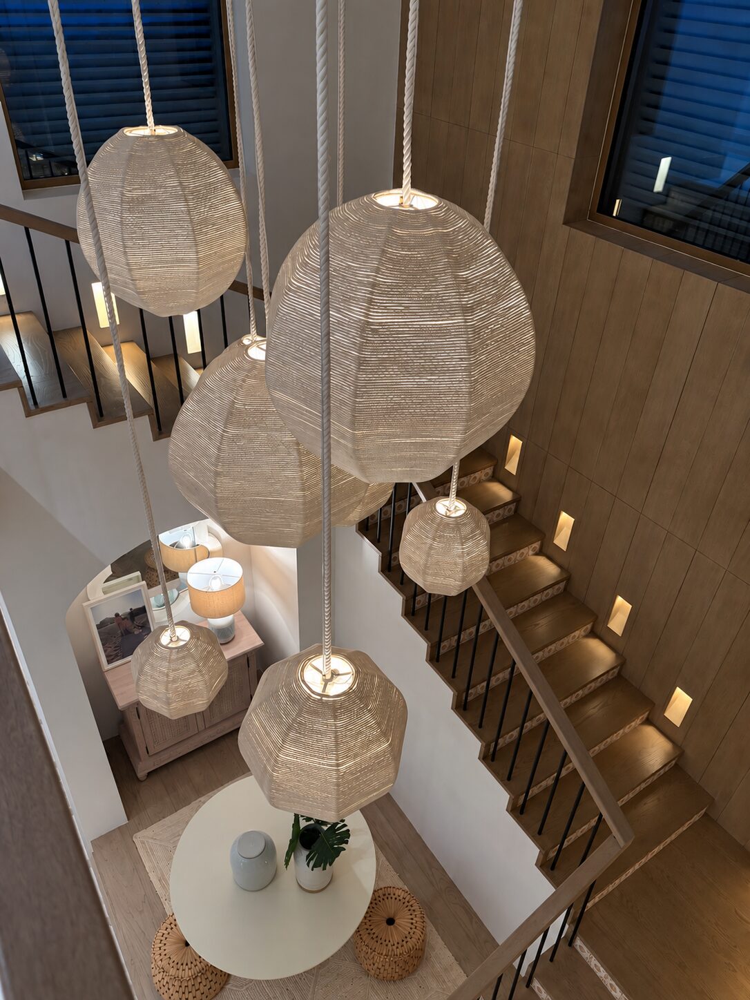 Stairwell of a Maravilla home hung with woven rattan pendant lamps