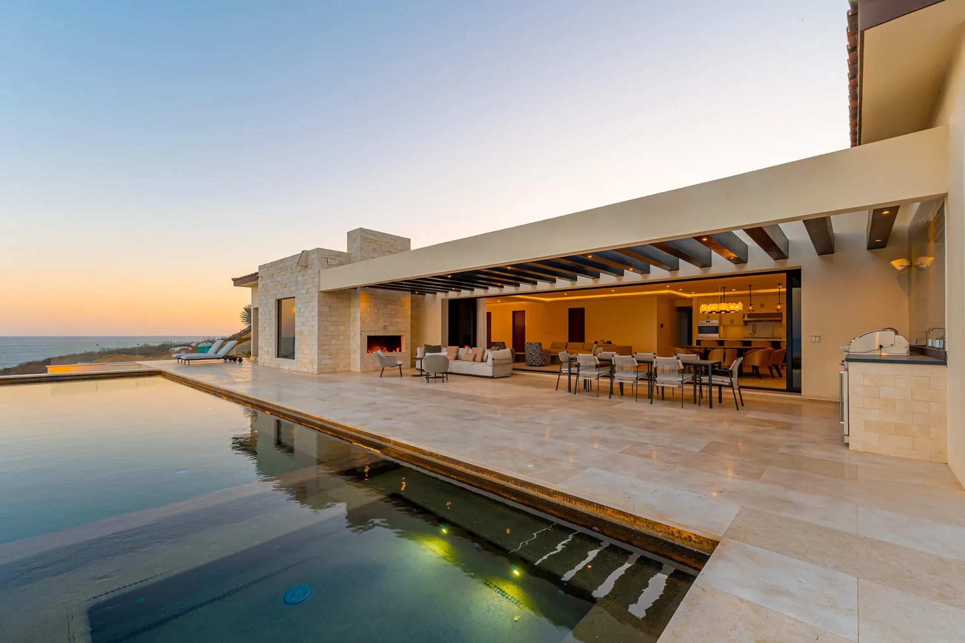Cielo Marbella residence at Quivira at dusk, open living room and long infinity pool facing the Pacific