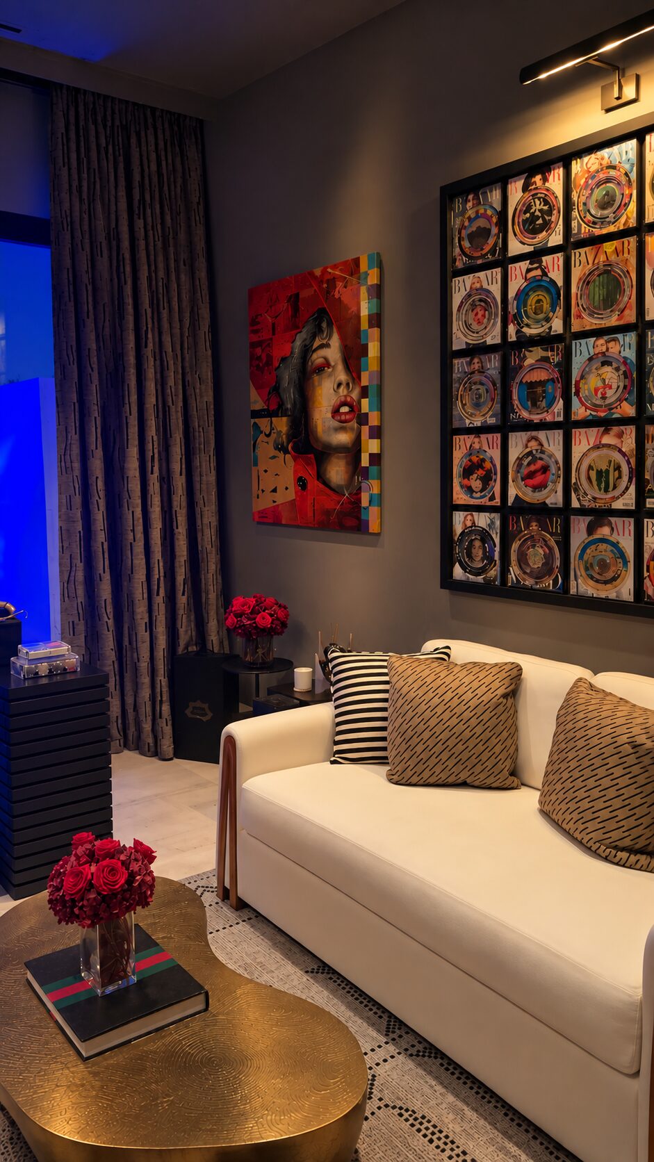 Sitting room of a Maravilla home with a gold cocktail table and a wall of framed prints