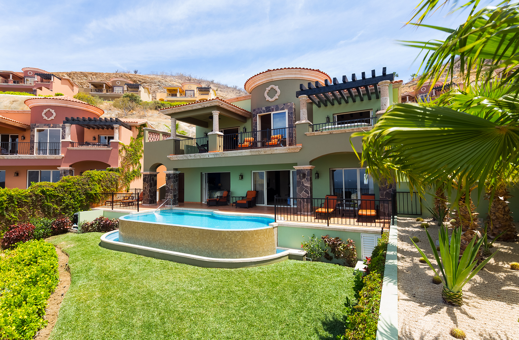 Montecristo Estates villas at Quivira, terracotta and green, each with its own pool