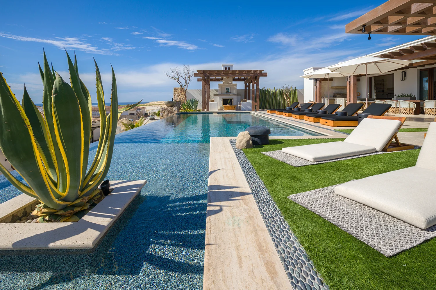Infinity pool and agaves at a Norman Estates residence overlooking the Pacific