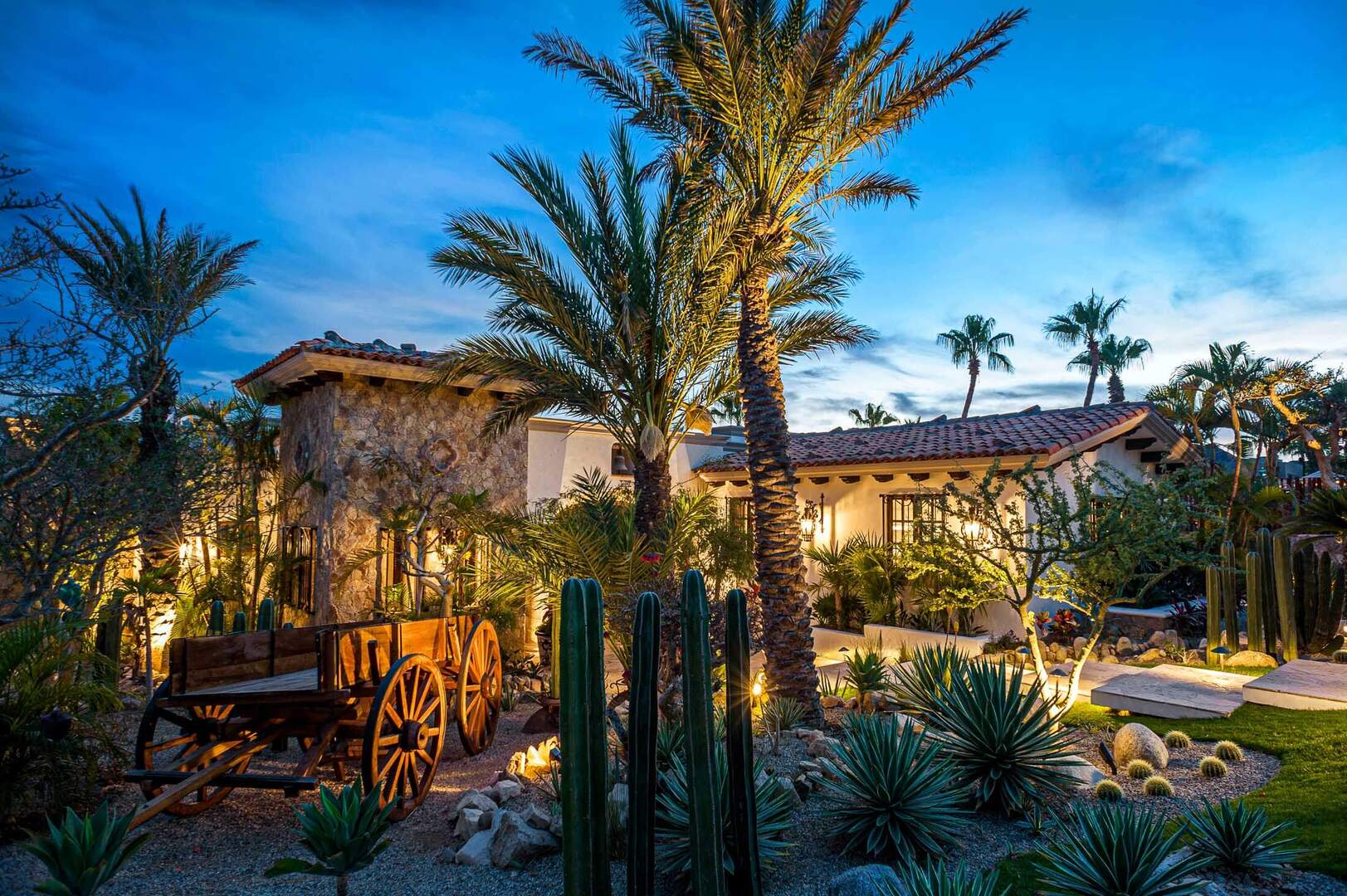 Hacienda-style home in Punta Ballena at dusk, with cactus garden and palms