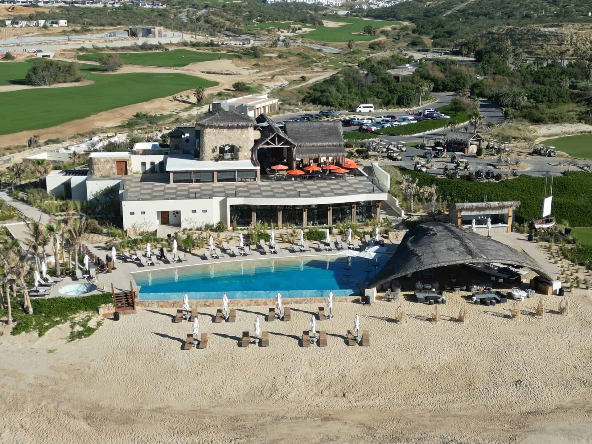 Aerial view of the Quivira Beach Club with its infinity pool and palapa on the sand